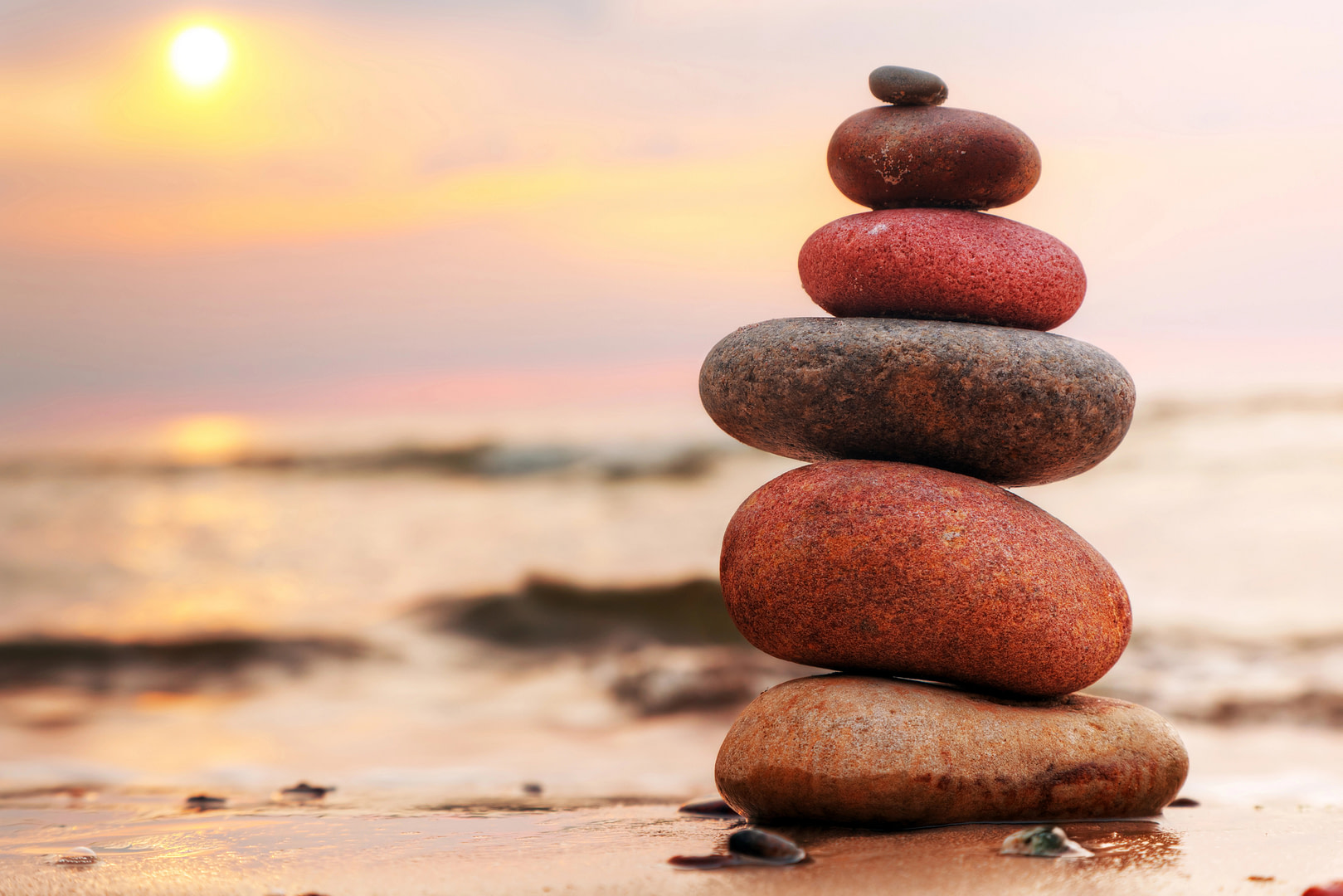 The essence of kindness Stones stacked on the beach at sunset portraying the essence of kindness.