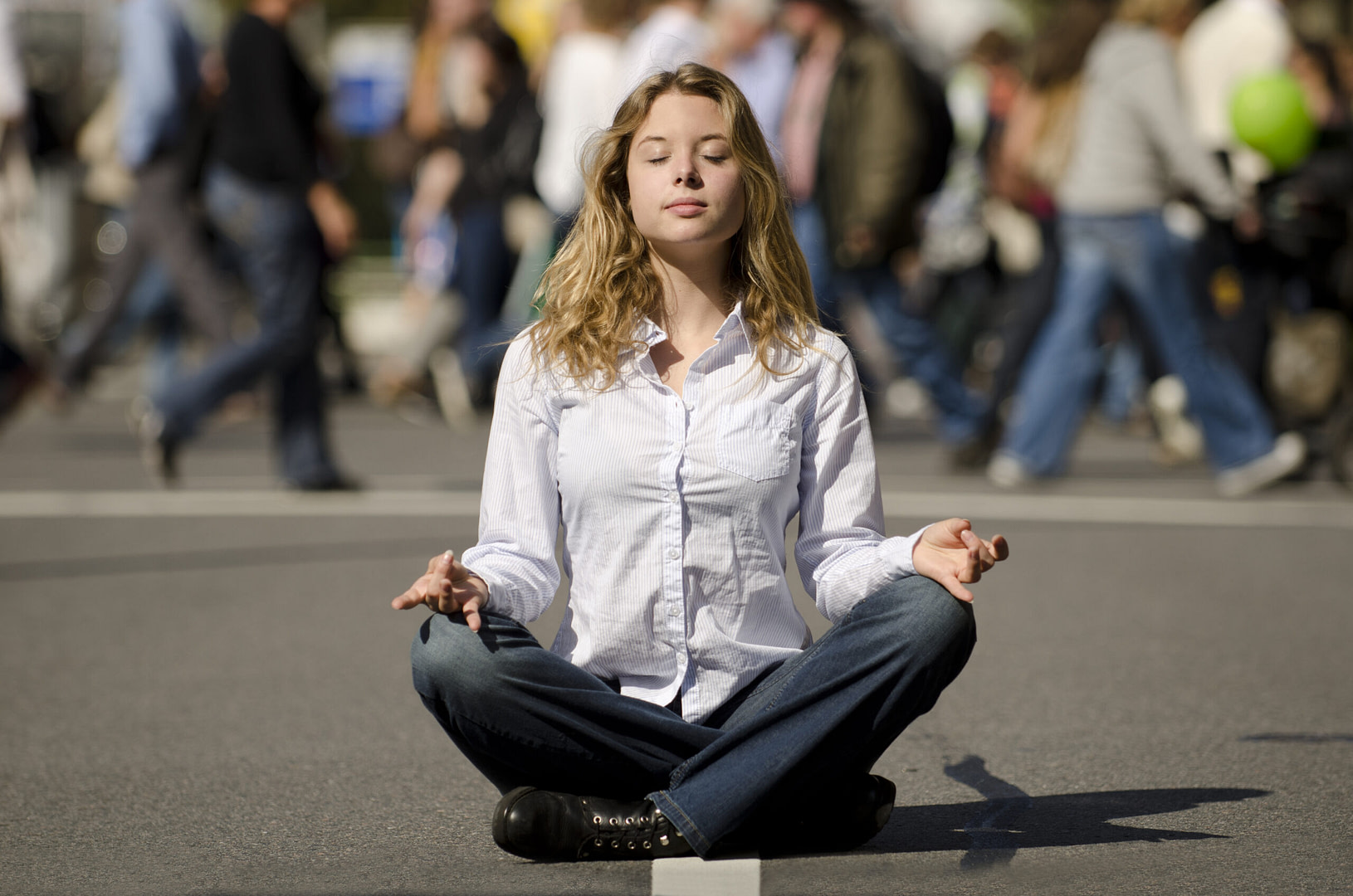 woman meditating on busy urban street