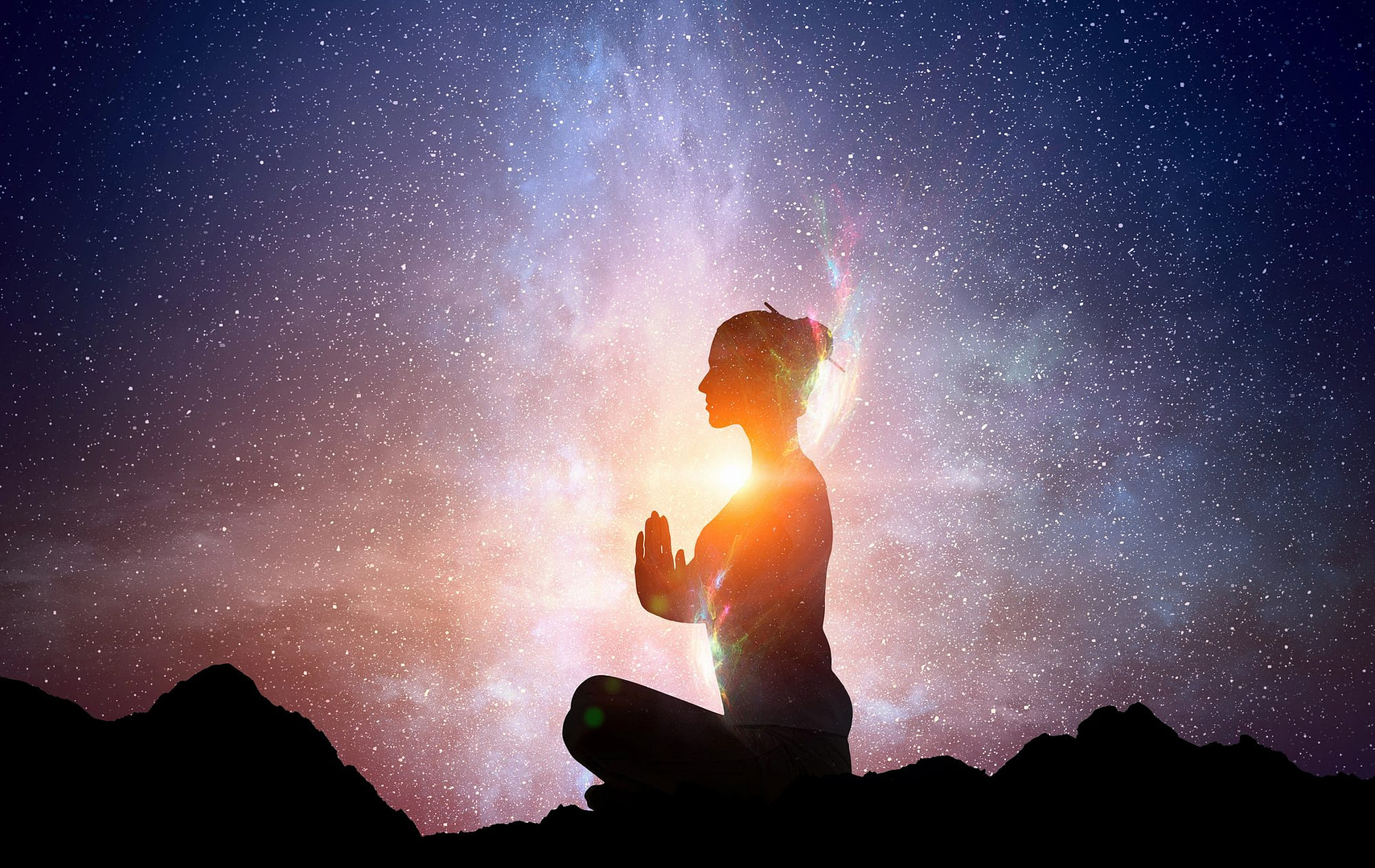 silhouette of woman in meditation post, stars and light behind emanating from chest - setting soul-aligned goals concept