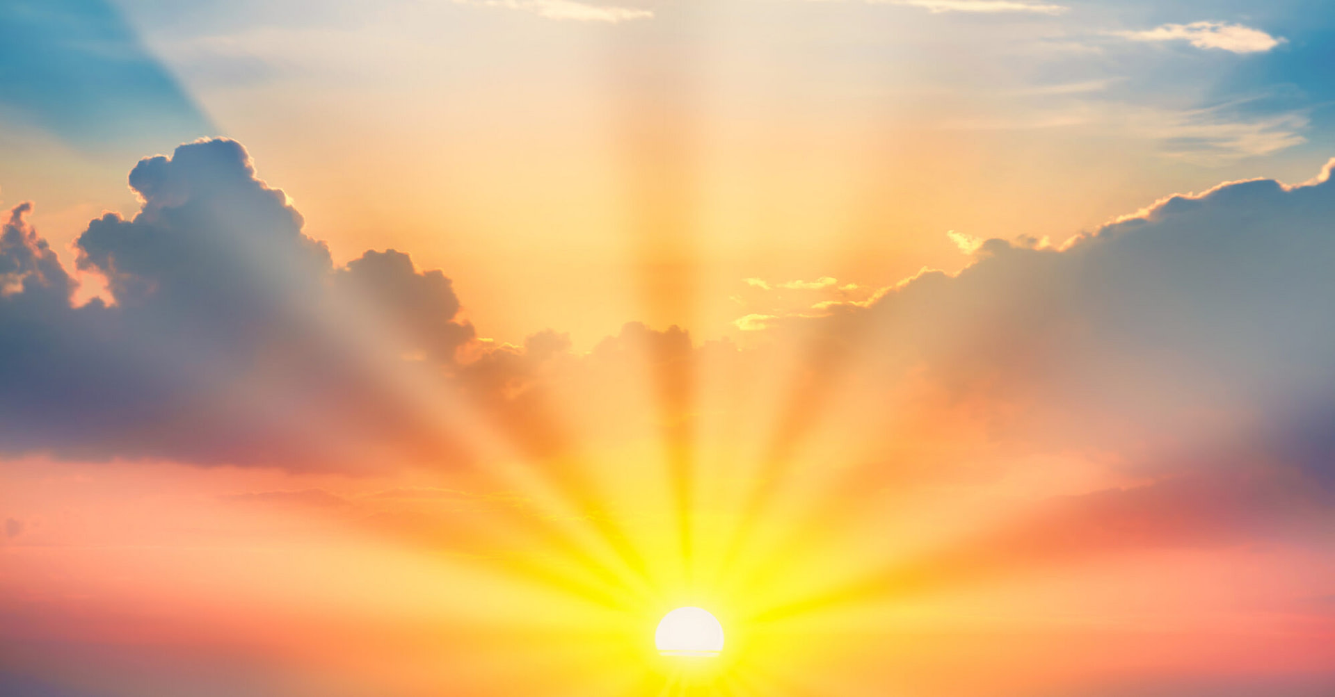 Sunset with sun and clouds on blue and orange dramatic sky with sun rays