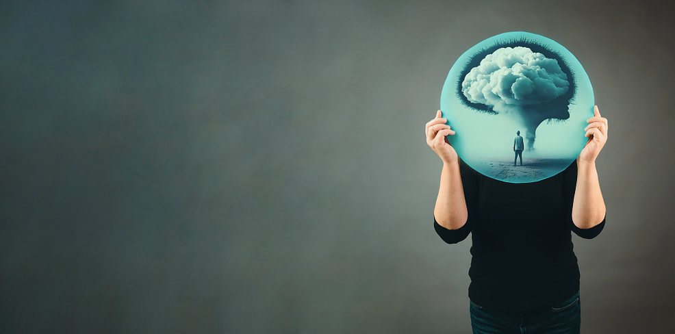 person holding up a picture in front of face with a brain full of clouds-representing what overwhelm and confusion feels like