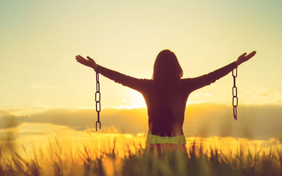 Woman feeling free Woman outside with hands outstretched and chains hanging from wrists, freedom concept