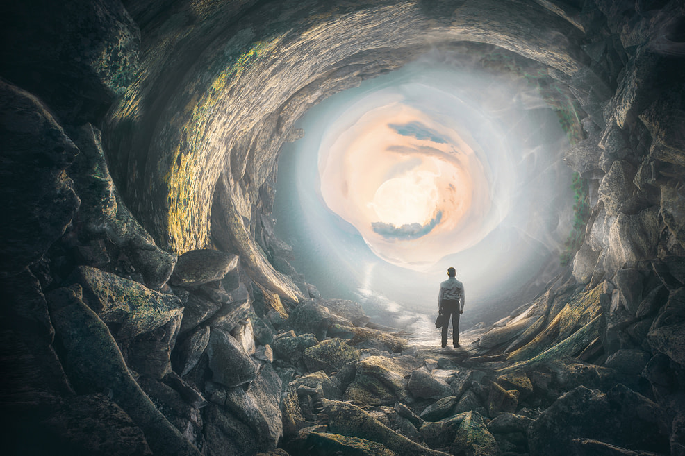 Man standing in cave, looking out at the light Man standing in cave, looking out at the light-choosing lightness in the power of anger