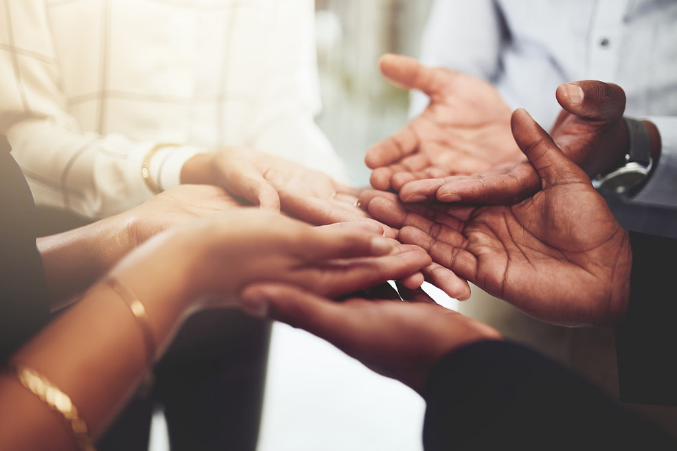 Coming together Closeup shot of a group of businesspeople standing with their hands cupped together