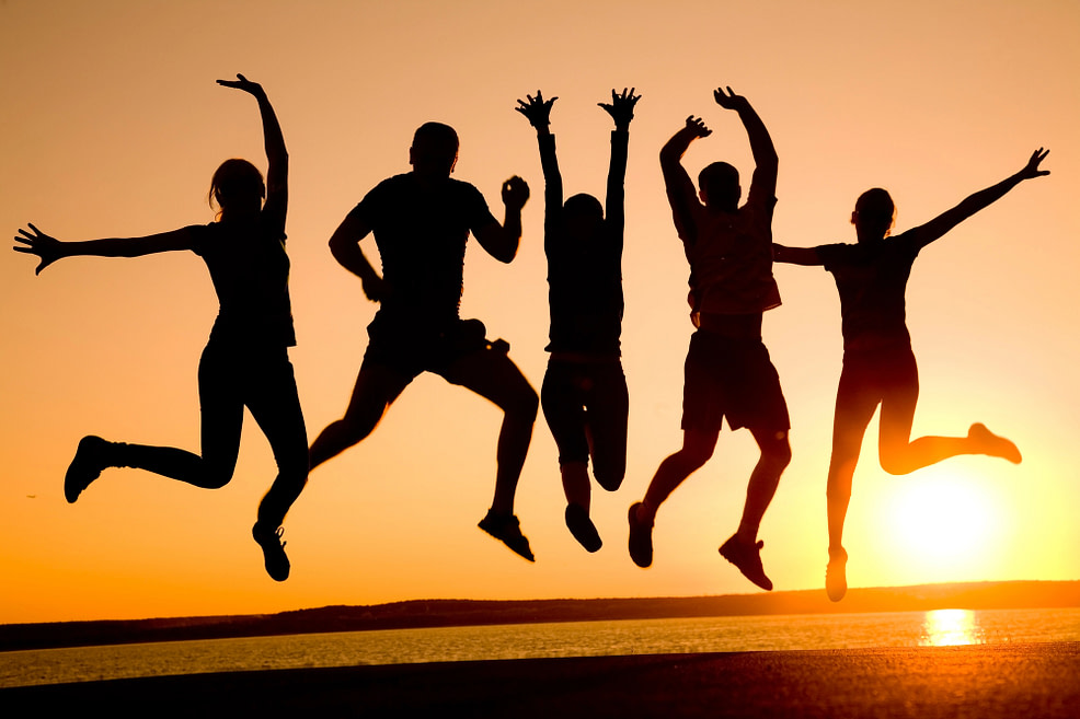 Connection sillhouette of 5 people in jumping in the air at sunset on a beach, living life to the fullest in connection
