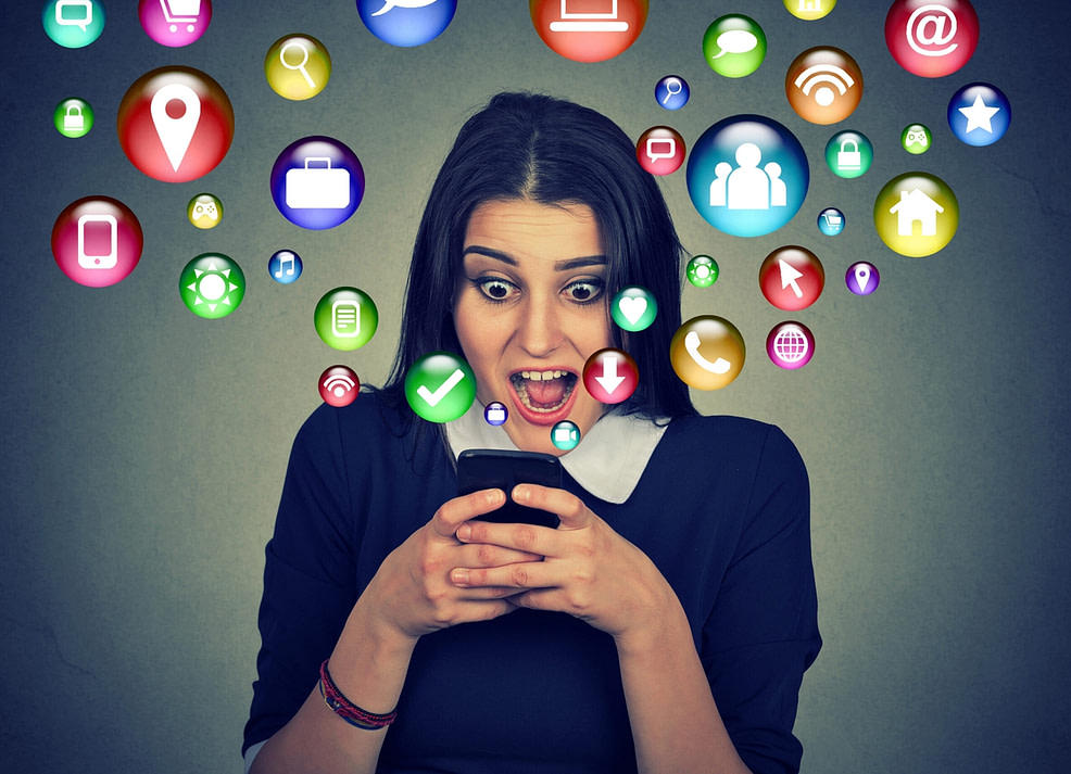 Woman absorbed in smartphone with icons flying out of the screen Woman absorbed in smartphone with icons flying out of the screen