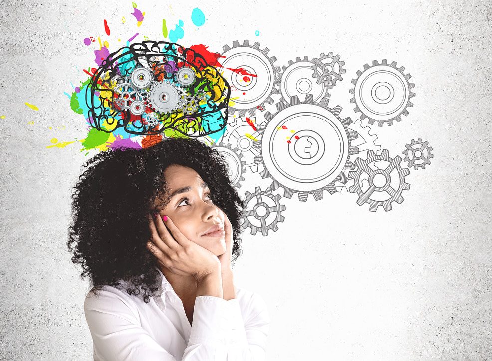Woman looking at colorful brain sketch with gears. Cultivating a monthly goal mindset. Woman looking at colorful brain sketch with gears. Cultivating a monthly goal mindset.