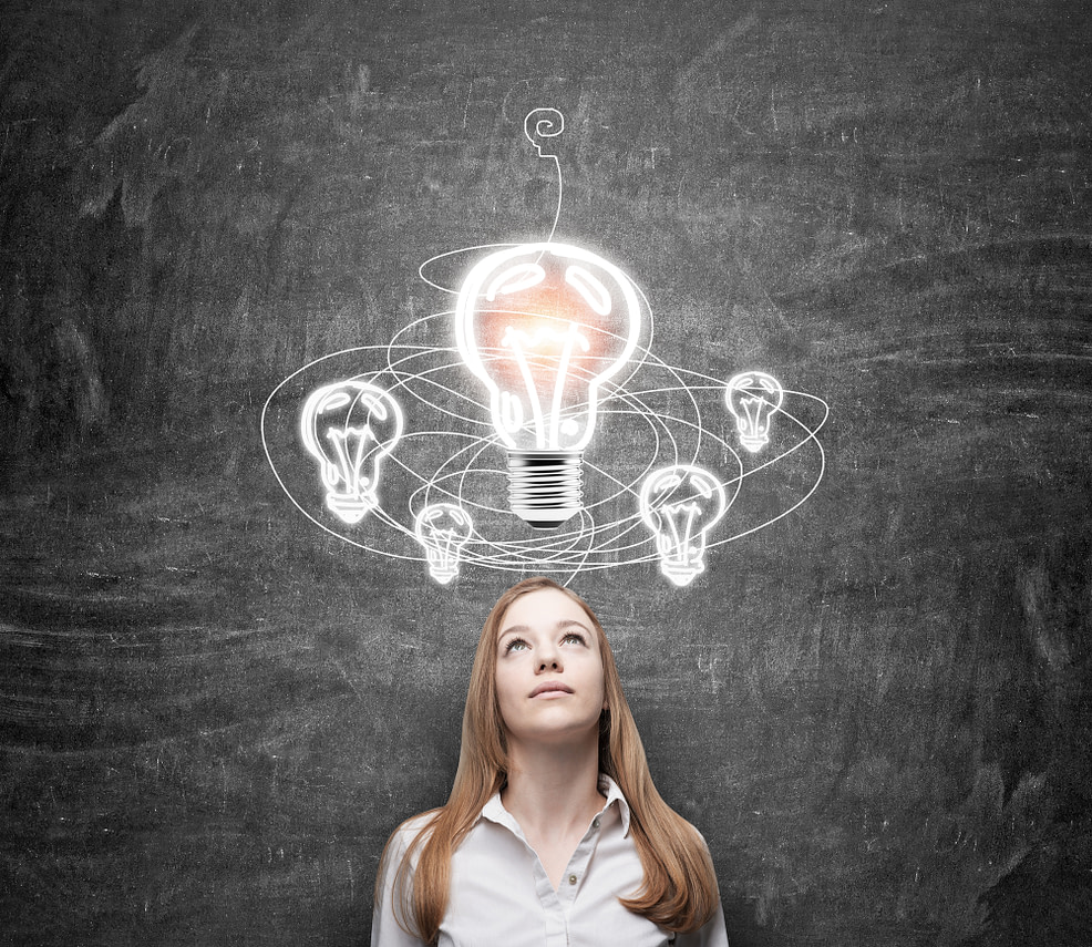 woman in search of solution young woman standing in front of a black wall looking at a white light bulb, looking for a solution of a problem, drawn bulbs over her head, a concept of finding a solution