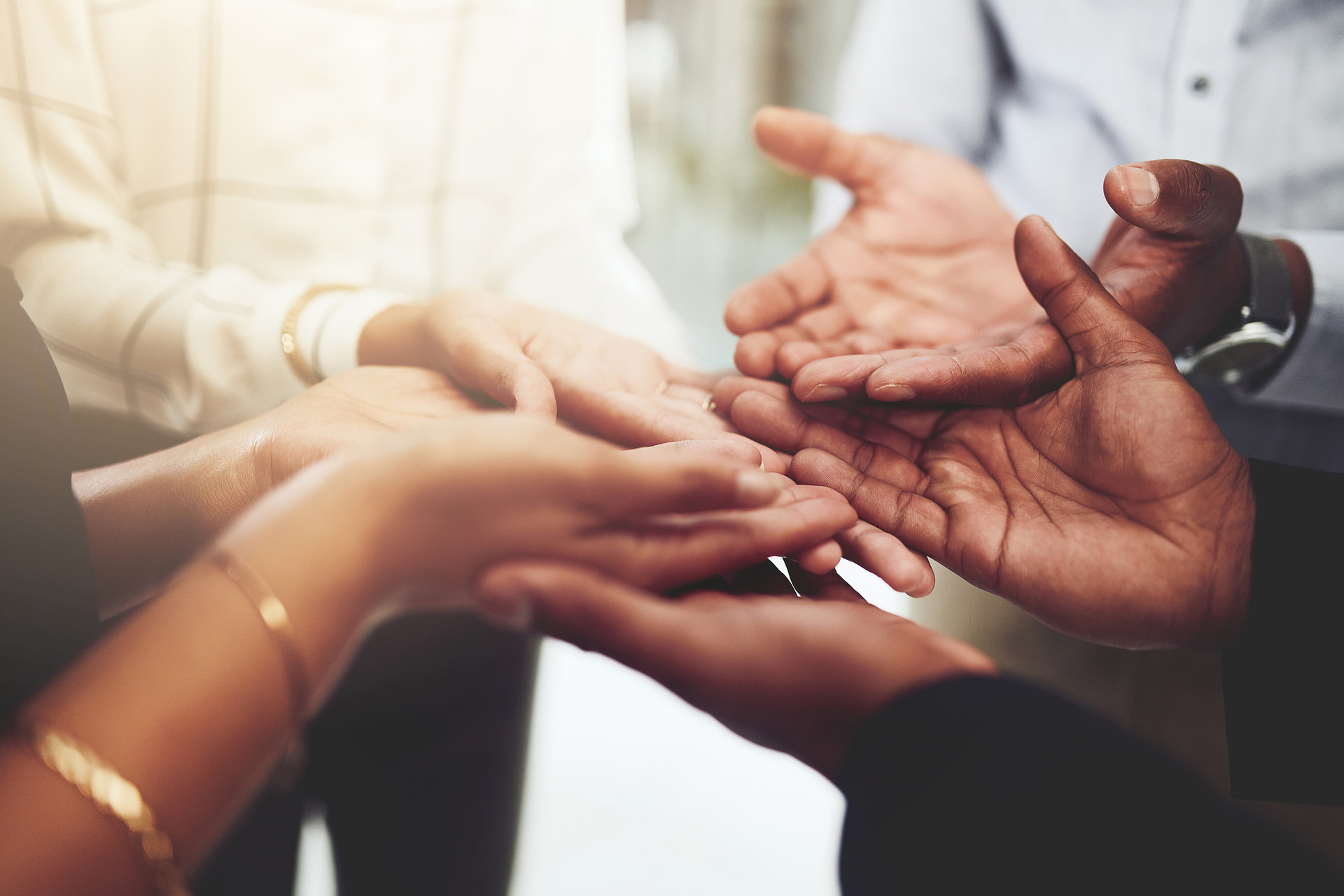 Closeup shot of a group of businesspeople standing with their hands cupped together