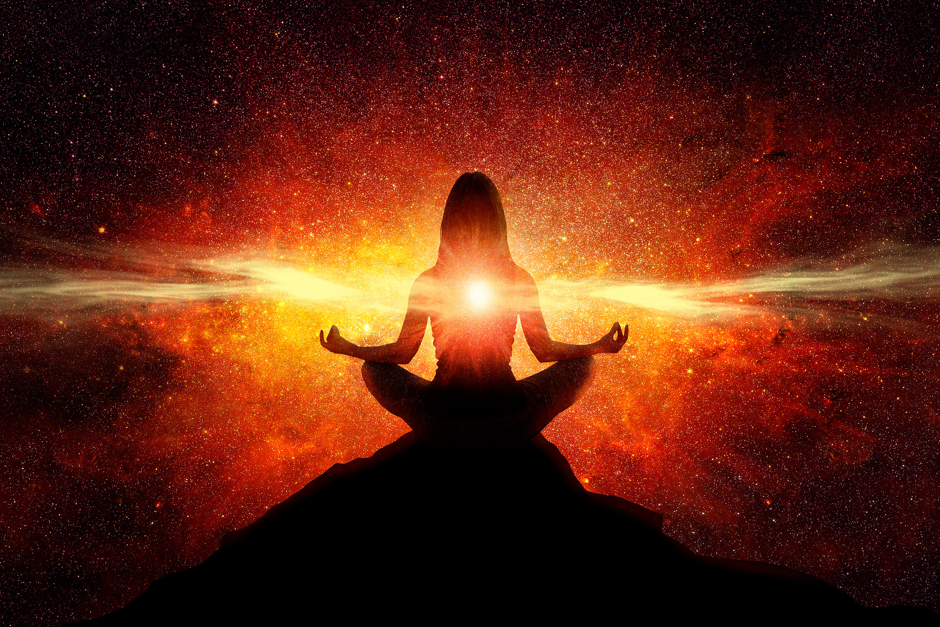Woman meditating on a hilltop connecting to the light at her heart center-tuning in to what it means to life life to the fullest